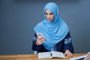Perempuan muslim melakukan Wakaf digital di Dompet Dhuafa melalui smartphone